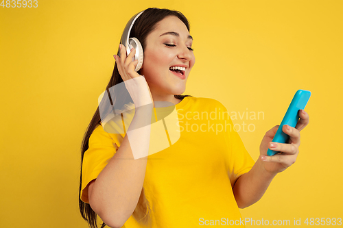 Image of Caucasian woman\'s portrait isolated on yellow studio background