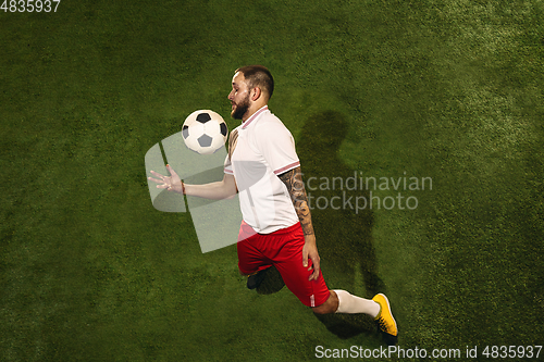 Image of Top view of caucasian football or soccer player on green background of grass