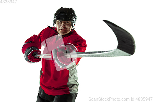 Image of Male hockey player with the stick on ice court and white background