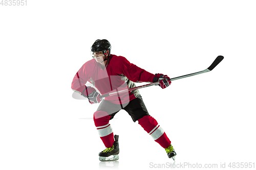 Image of Male hockey player with the stick on ice court and white background