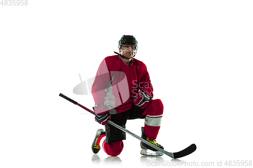 Image of Male hockey player with the stick on ice court and white background