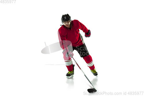 Image of Male hockey player with the stick on ice court and white background