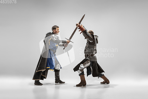 Image of Brave armored knights fighting isolated on white studio background