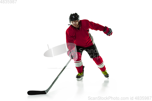 Image of Male hockey player with the stick on ice court and white background