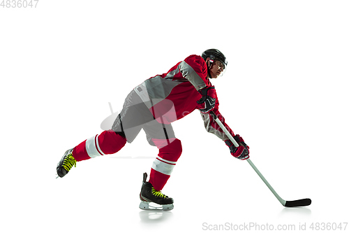 Image of Male hockey player with the stick on ice court and white background