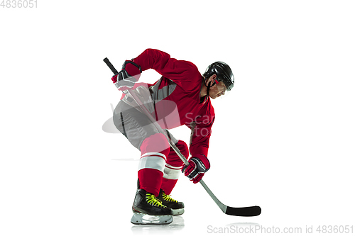 Image of Male hockey player with the stick on ice court and white background