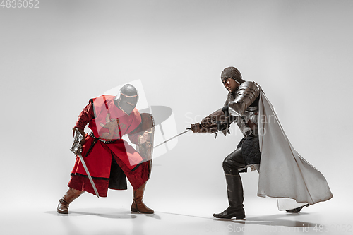 Image of Brave armored knights fighting isolated on white studio background