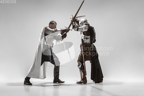 Image of Brave armored knights fighting isolated on white studio background