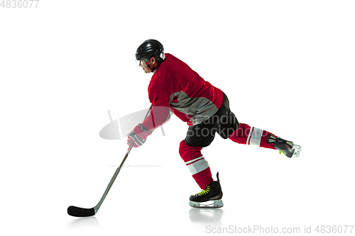 Image of Male hockey player with the stick on ice court and white background