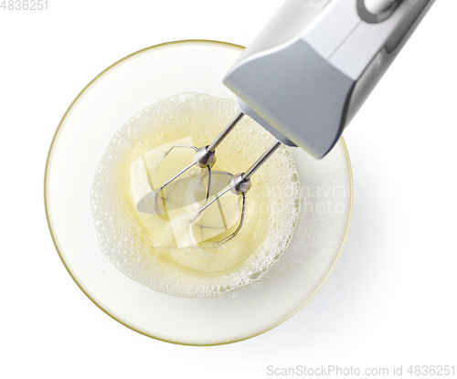 Image of beating egg whites cream with mixer in the bowl