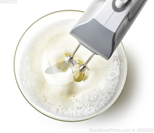 Image of beating egg whites cream with mixer in the bowl