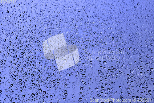 Image of Water drops on glass, blue natural background