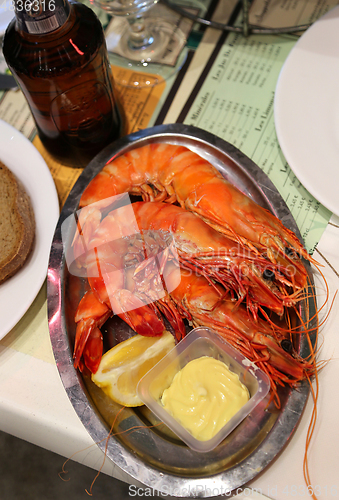 Image of Jumbo shrimps with lemon and sauce on metal plate