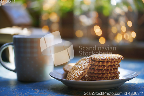 Image of Teacup and Christmas gluten free cookies on a table near the win