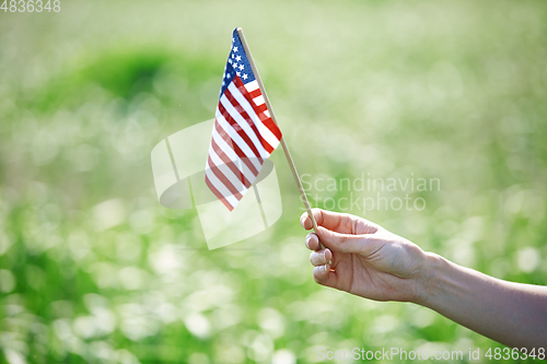 Image of Hand holding US flag for Independence Day