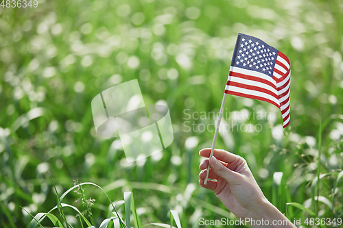 Image of Hand holding US flag for Independence Day