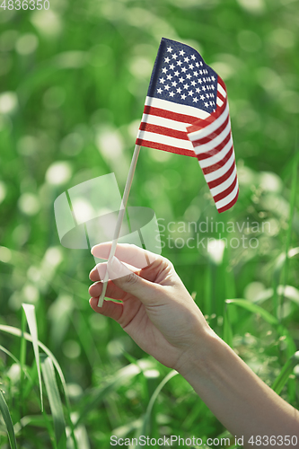 Image of Hand holding US flag for Independence Day