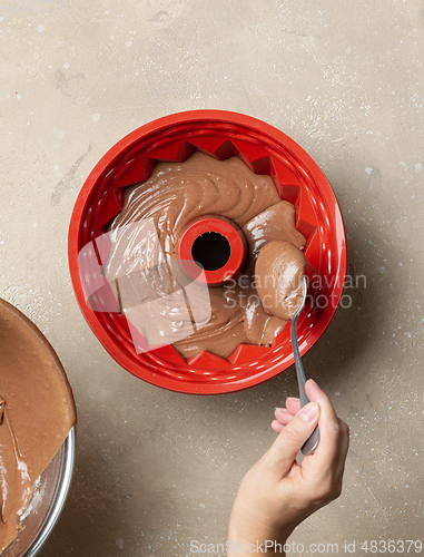 Image of putting chocolate cake dough in silicone baking form