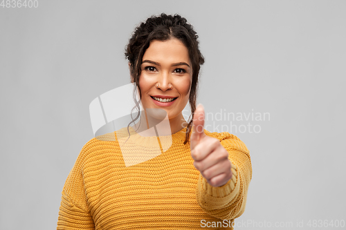 Image of happy smiling young woman showing thumbs up