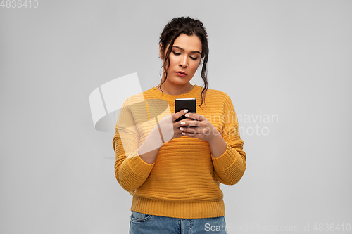 Image of sad woman using smartphone