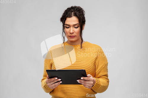 Image of serious young woman using tablet pc computer