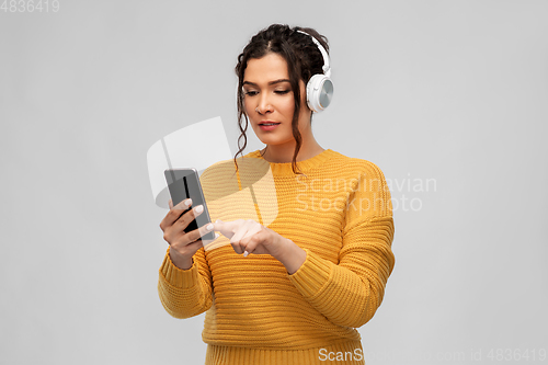 Image of woman in headphones with smartphone