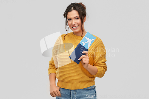 Image of happy young woman with air ticket and passport