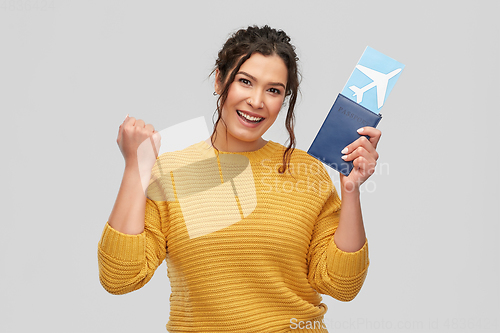 Image of happy young woman with air ticket and passport