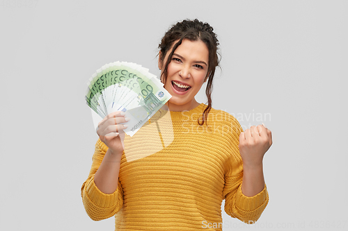 Image of happy smiling young woman with euro money