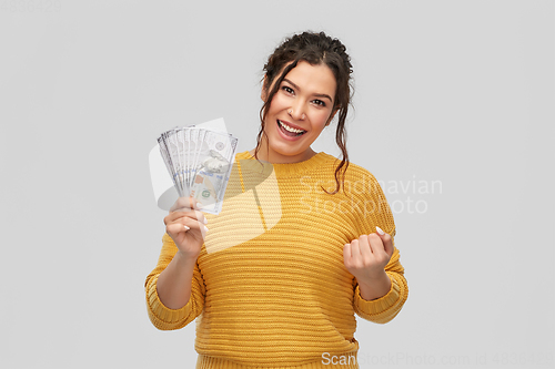 Image of happy smiling young woman with dollar money