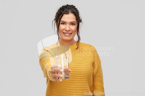 Image of smiling young woman with water in glass