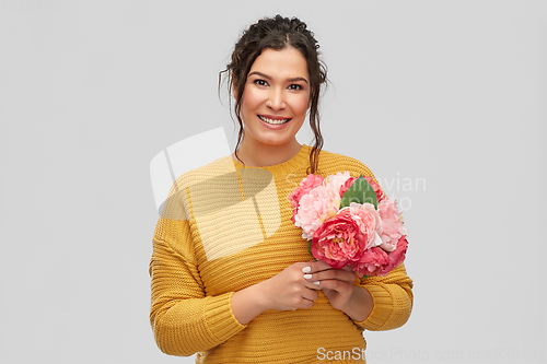 Image of happy smiling young woman with bunch of flowers