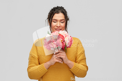 Image of happy smiling young woman with bunch of flowers