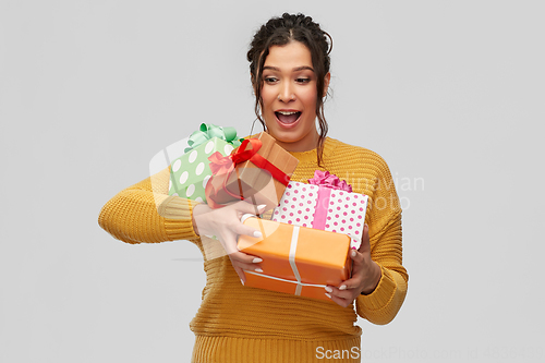 Image of smiling young woman holding gift boxes