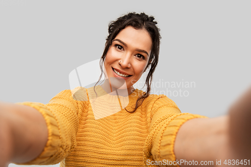 Image of smiling woman with pierced nose taking selfie