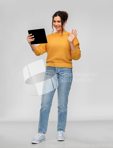 Image of happy young woman having video call on tablet pc