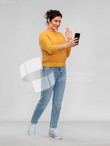 Image of happy young woman having video call on smartphone
