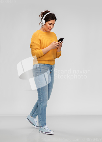 Image of woman in headphones with smartphone