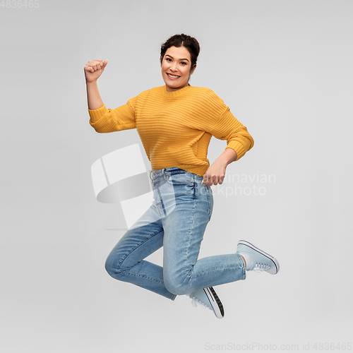 Image of happy young woman with pierced nose jumping