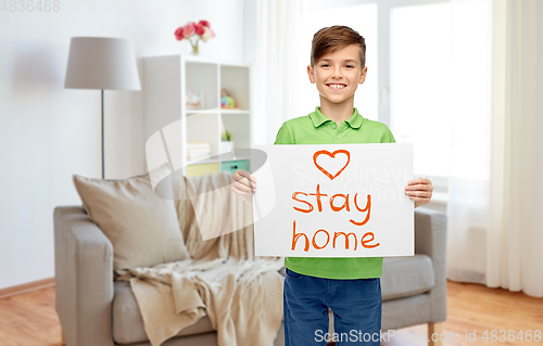 Image of happy boy holding stay home message on paper