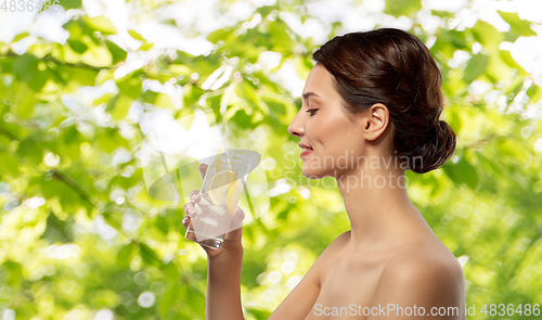 Image of woman drinking water with lemon and ice