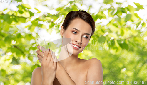 Image of woman applying moisturizing cream to her hand