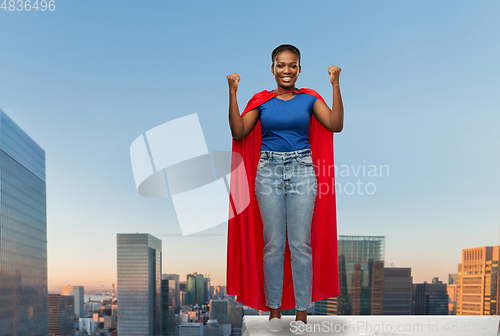 Image of happy african american woman in red superhero cape