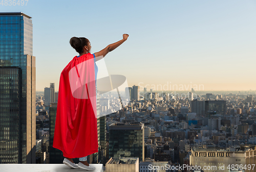 Image of happy african american woman in red superhero cape