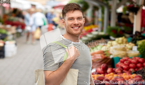 Image of man with reusable shopping bag at street market