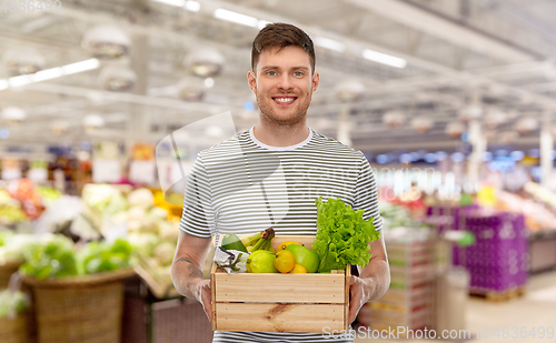 Image of happy smiling man with food in wooden box