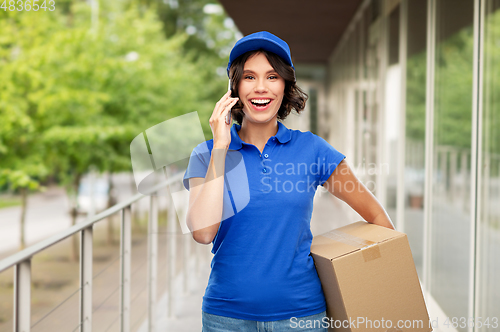 Image of delivery girl with parcel box calls on smartphone