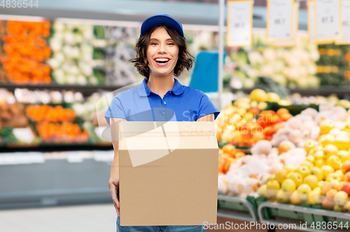 Image of happy delivery girl with box at grocery store
