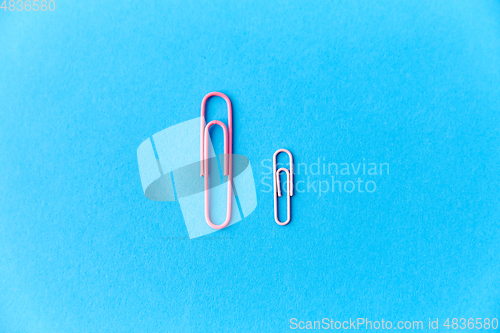 Image of pink office clips on blue background