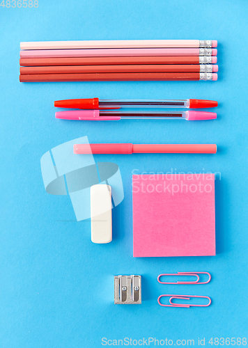 Image of pink sticky notes, pens, pencils, clips and eraser